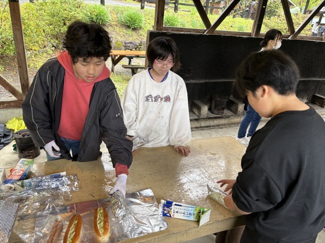 パンにキャベツをはさみ、ウィンナーも入れます。アルミホイルで包み、牛乳パックに入れます。牛乳パックに火をつけて、牛乳パックが燃えたらできあがり。